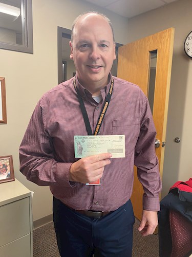 Andy holding a check