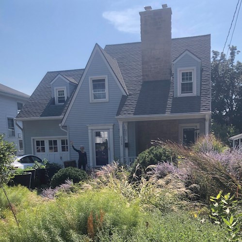 Susan stands in front of her house