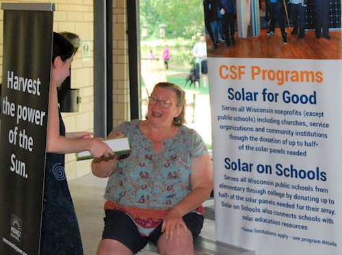 Woman next to solar power sign