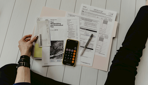 papers on the floor with a calculator