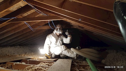 Stephen posing for a photo as he is improving air sealing and insulation in his attic.