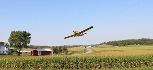 Crop plane flies over farm