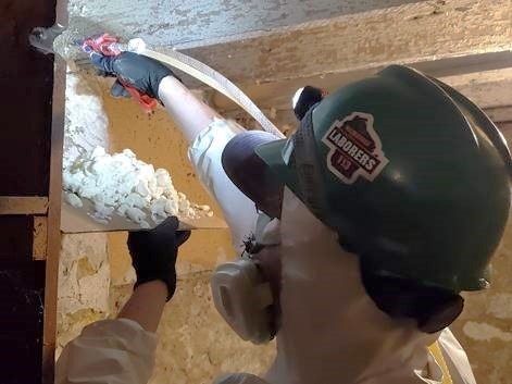 Man in flannel installing insulation