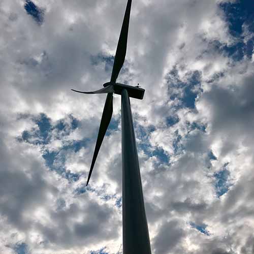 Wind turbine against cloudy sky