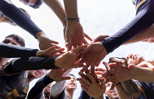 group of people bringing their hands together in a circle